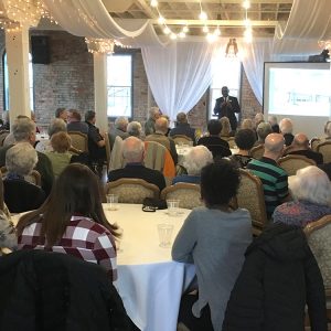President Joe Manickam presents about current events at the college to a group of Hesston College alumni and friends at a gathering in Goshen, Ind.