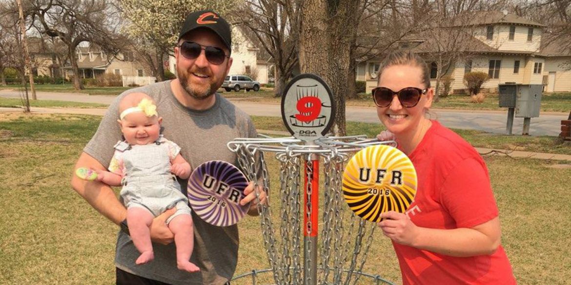 CJ (Unruh) Byler along with her husband, Billy, and daughter, Hazel, play a round of disc golf at Hesston College on the newly installed course in memory of her father, Doug.