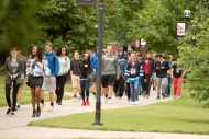 Students walk the avenue of flags.