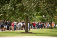 Students walk the avenue of flags.