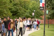 Students walk the avenue of flags.