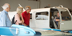 Chris Lichti talks about one of the planes in the Hesston College Aviation fleet with his parents, Tim and Judy Lichti, and friend Bill Armfield.