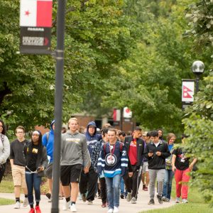 During Peace Day 2018, students walk the Hesston College Global Walkway, which is lined with flag representations of the countries Hesston College students call home.