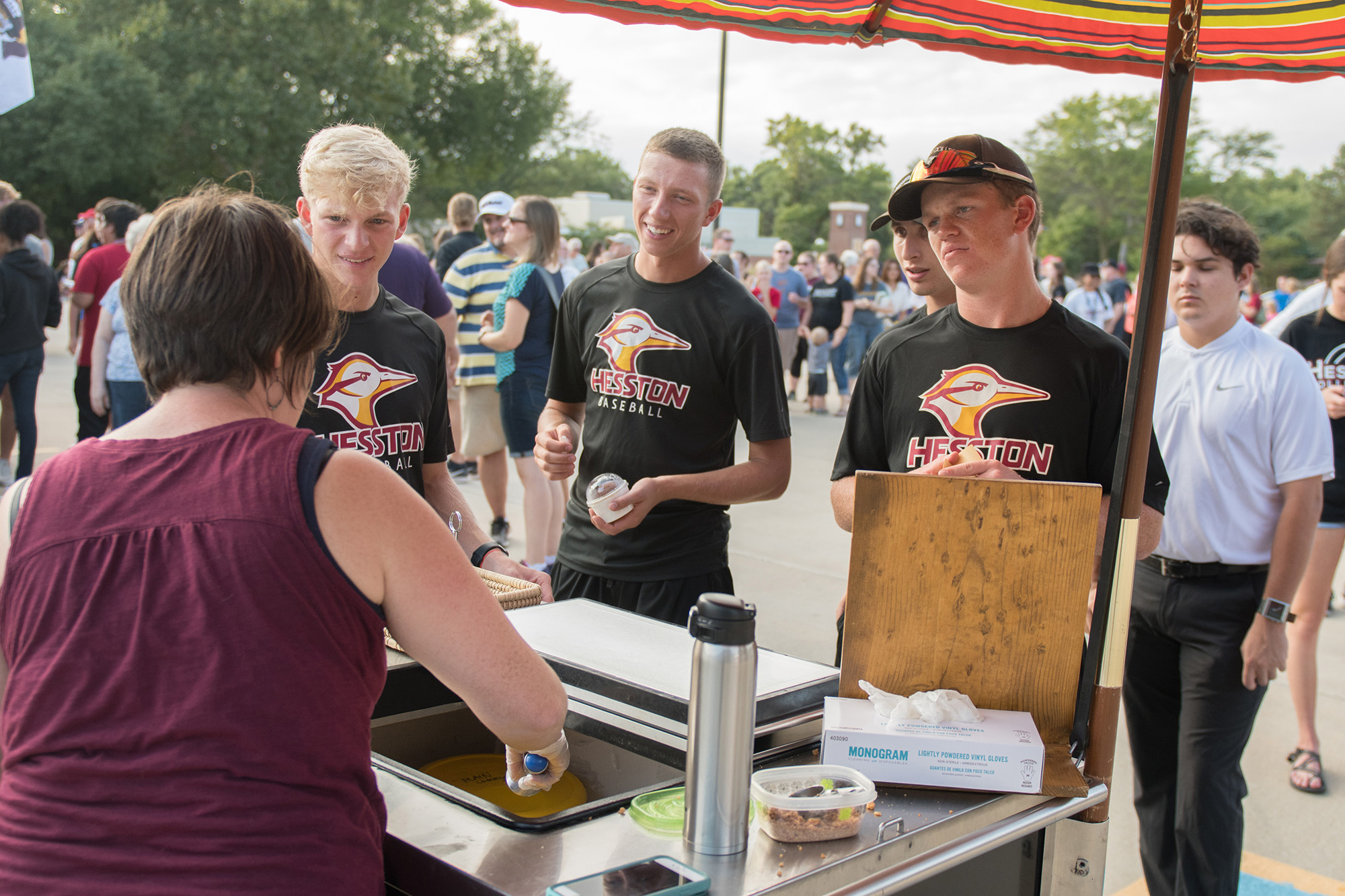 Communication prof and Salted Creamery owner Kendra Burkey serves ice cream to a quartet of Lark baseball players at the food truck supper.