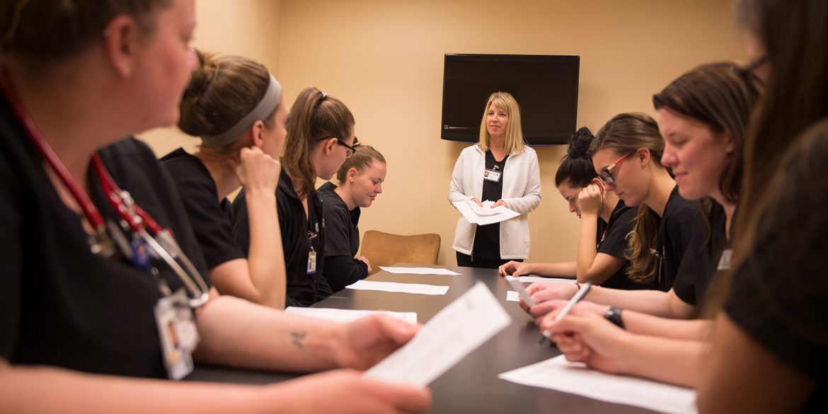 Students meet with faculty member Sharon Woodward to debrief after a clinical shift.