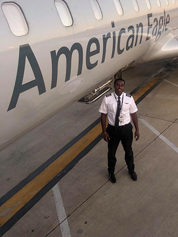 Ashenafi Tadese stands next to the American Eagle plane he flies