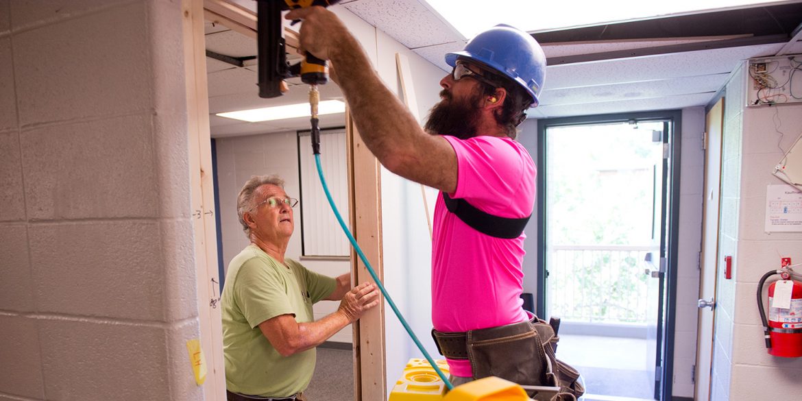 Mennonite Disaster Service volunteers Don Horst and Jordan Miller install a wall to add a room to a Kauffman Court mod.