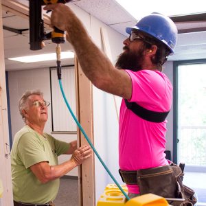 Mennonite Disaster Service volunteers Don Horst and Jordan Miller install a wall to add a room to a Kauffman Court mod.