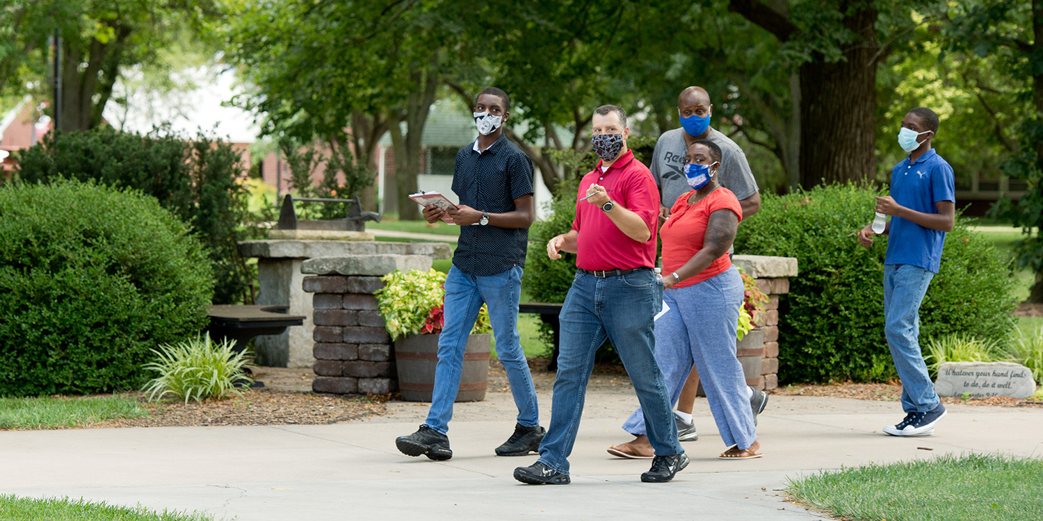 Assistant Director of Admissions Charles Hostetler leads a campus tour with a prospective student and his family.