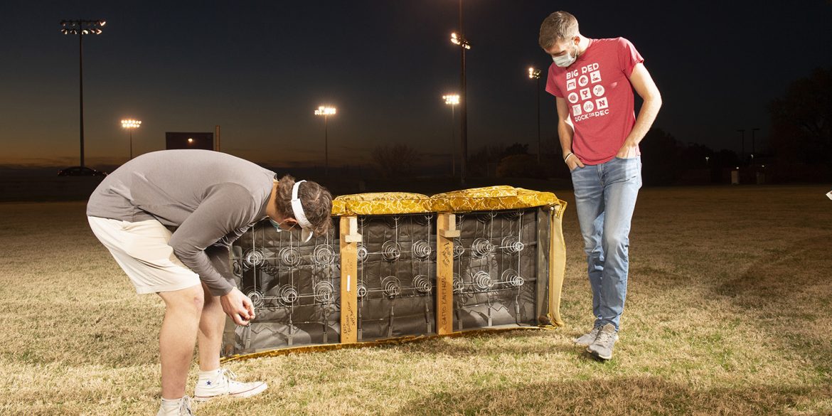 Jacob Mullins and Chris Lichti inspect Goldy's underside, where previous caretakers have written their names.