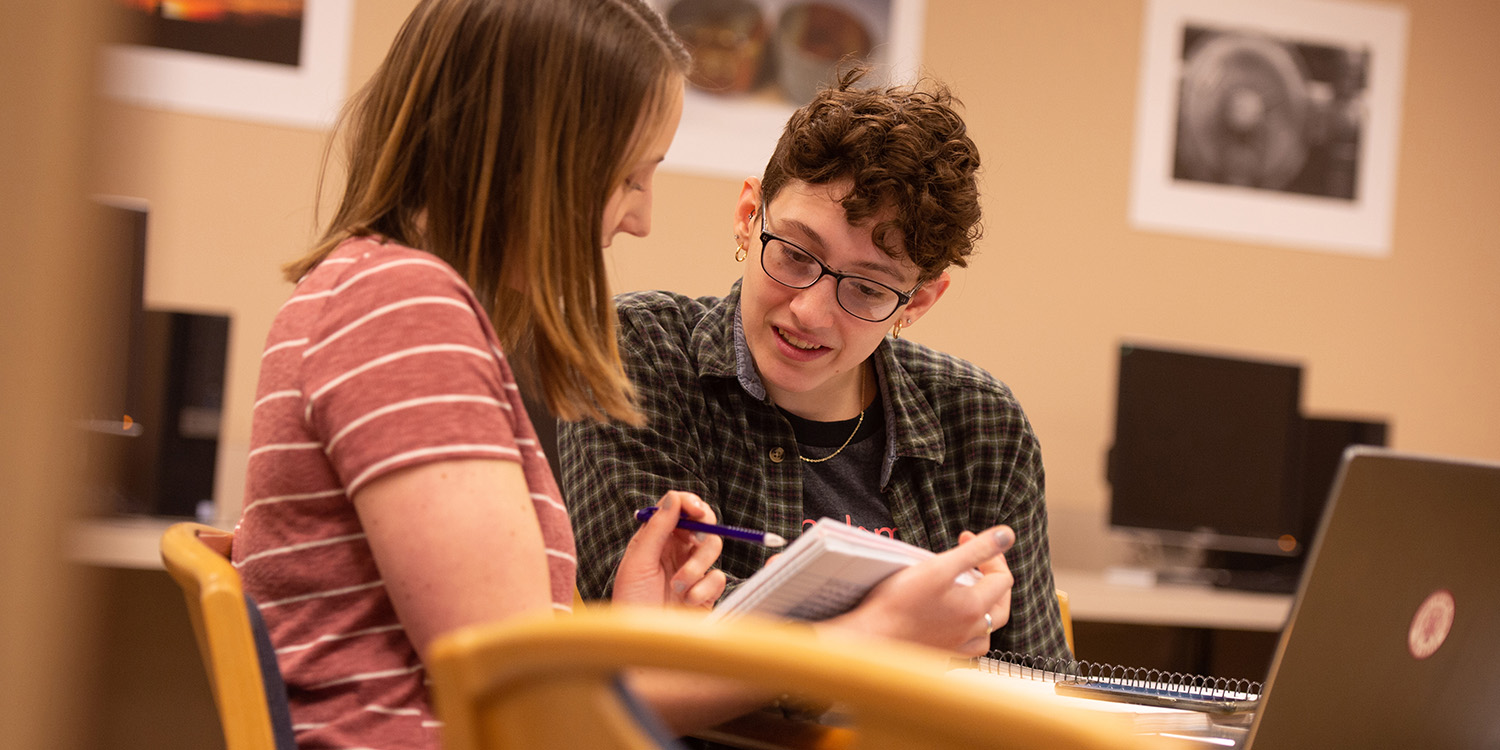 Writing Assistant Lys Nolt helps a student with their writing project in the Access lab.