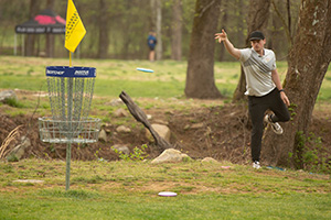 Senior Toby Yoder putts at the College Disc Golf national tournament, North Cove Club, North Carolina