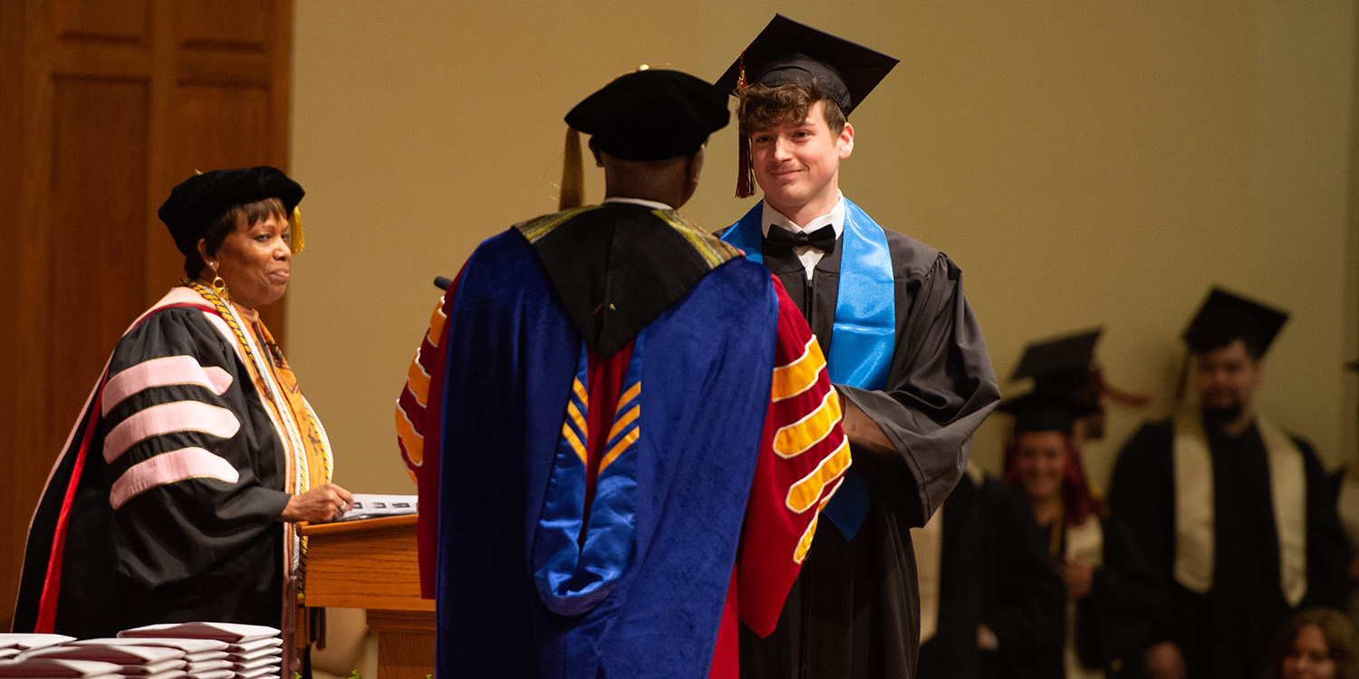 photo - Tobias Yoder receives his Bachelor of Science diploma from President Joseph A. Manickam.