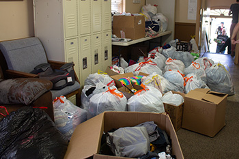 Photo - Donations begin to pile up inside New Hope Shelter while Hesston College Nursing Club students work to unload four vehicles filled with clothes, food, hygiene supplies and other items.