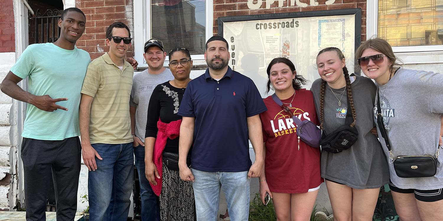 Photo - Bryce Blake, Johann Reimer, Keith Showalter, Wideline Charles, Juan Marrero, Emily Miller, Smilla Burklin and Kelbe Edwards at Crossroads Community Center in Fairhill hood.