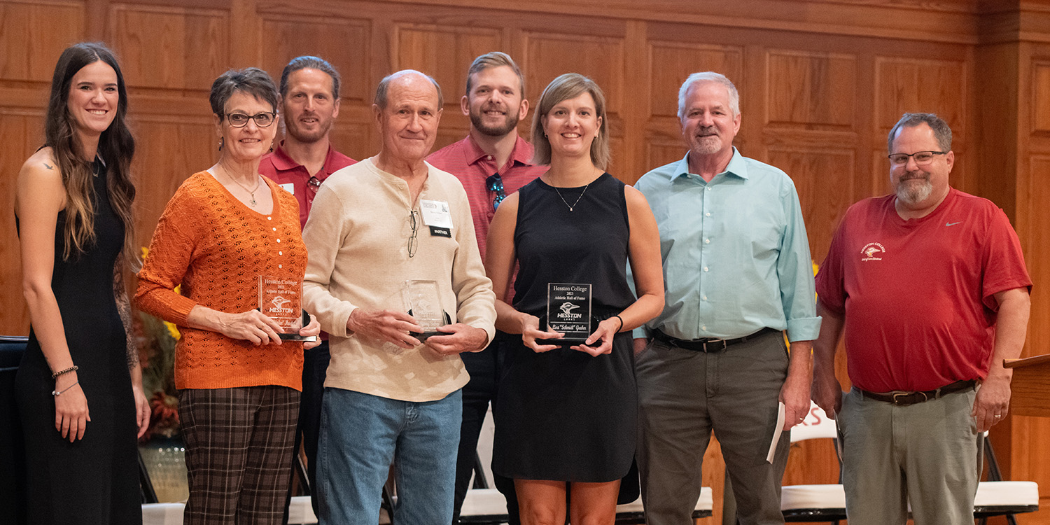 photo - several members of the inaugural class of the Hesston College Athletics Hall of Fame pose with current and former coaches and administrators.