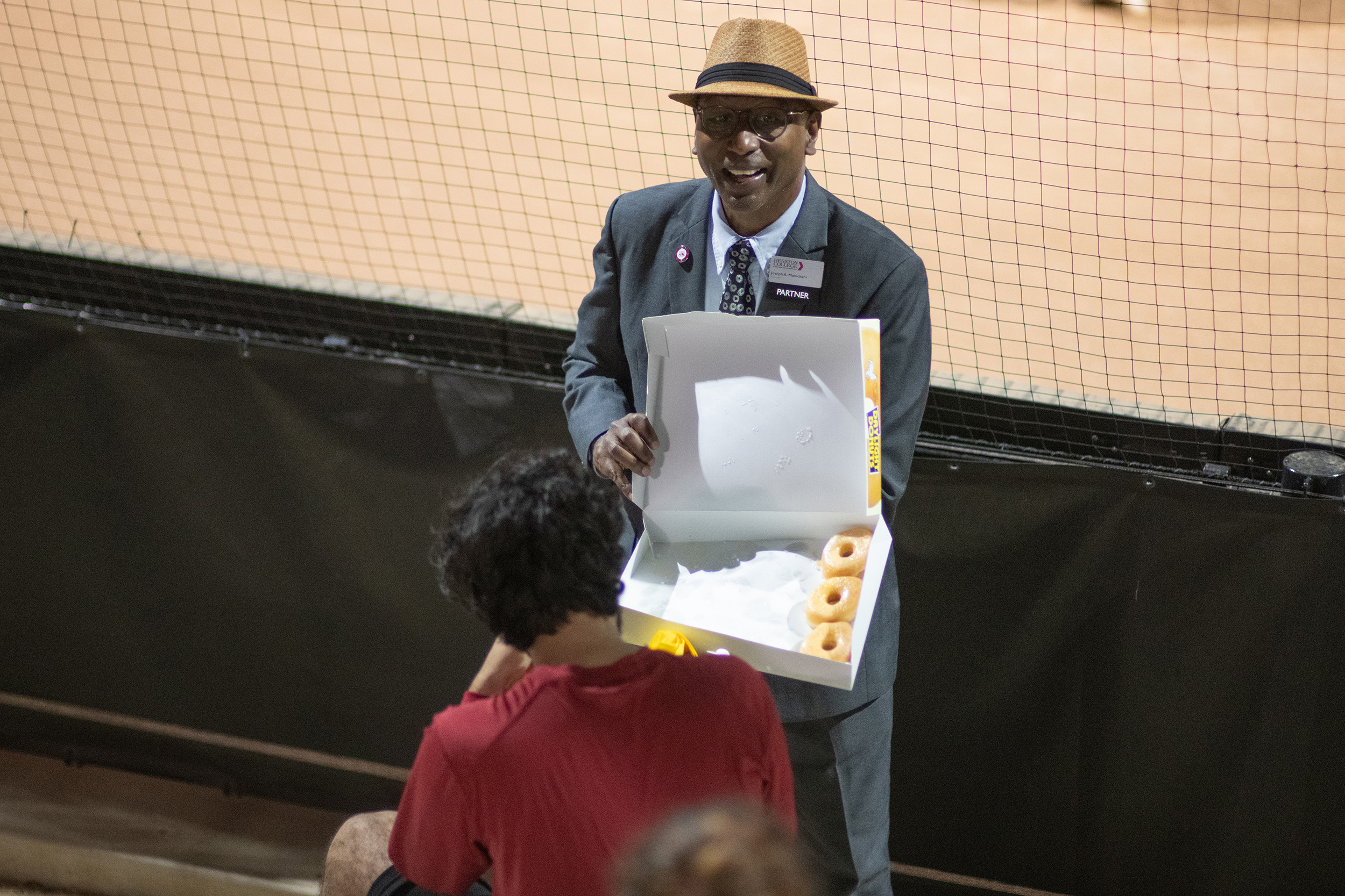 photo - Hesston College Homecoming 2023 - President Manickam hands out donuts at the Reverse Druber's Run